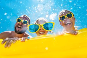 Family having fun on summer vacation. People jumping in swimming pool. Active lifestyle concept. Spring break! SeaWorld Tickets For $49