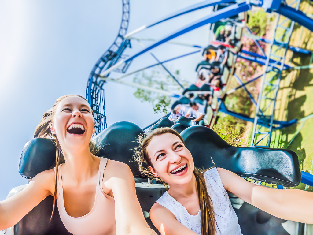 Two happy girls having fun on rollercoaster.