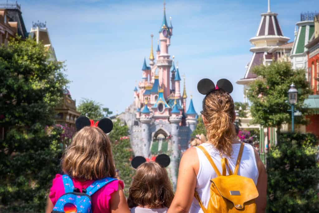 A mother and her daughters gaze at the Princess Castle at Disney